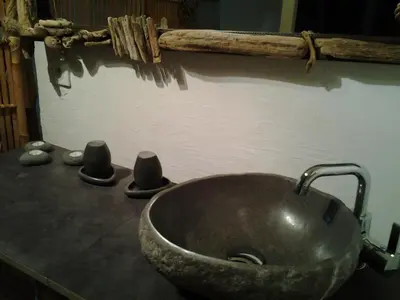 a bathroom with a stone sink and two stools at Chambre d'Hôtes La Marlotte in Castello-di-Rostino