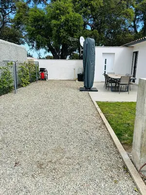 a backyard with a table and a grill and a fence at Villa Climatisée avec Piscine partagée , Terrasse et Parking in Prunelli-di-Fiumorbo