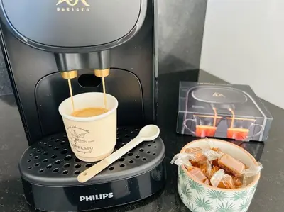 a coffee maker with a cup of coffee and a container at Villa Climatisée avec Piscine partagée , Terrasse et Parking in Prunelli-di-Fiumorbo