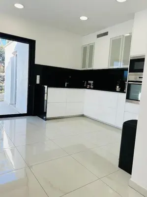 a large room with a kitchen with white counters at Villa Climatisée avec Piscine partagée , Terrasse et Parking in Prunelli-di-Fiumorbo