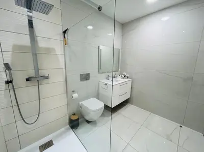 a white bathroom with a shower and a toilet at Villa Climatisée avec Piscine partagée , Terrasse et Parking in Prunelli-di-Fiumorbo