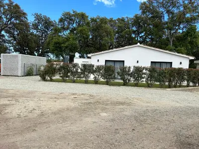 a white house with bushes in front of it at Villa Climatisée avec Piscine partagée , Terrasse et Parking in Prunelli-di-Fiumorbo