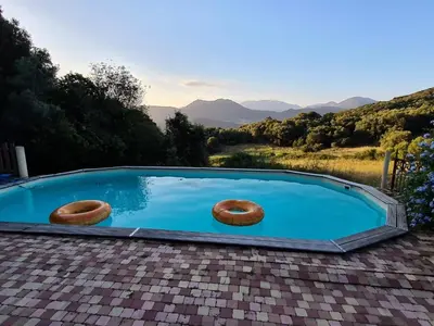 a swimming pool with three donuts in the water at BERGERIE DE 1770 AVEC PISCINE in Sartène