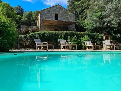 a pool with chairs and a house in the background at BERGERIE DE 1770 AVEC PISCINE in Sartène