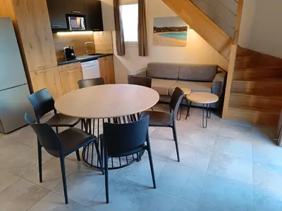 a kitchen and dining room with a table and chairs at T3 Picchiarini, Clim, piscines, resto, 5' plages in Lecci