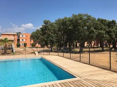 a swimming pool with a fence and trees at T3 Picchiarini, Clim, piscines, resto, 5' plages in Lecci