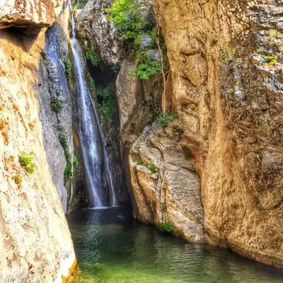 a waterfall in a pool of water between two rocks at I Tre Taglincchi, U Sicondu - Proche mer, Clim, Wifi, Parking gratuit in Taglio-Isolaccio
