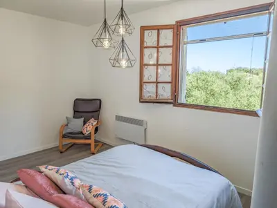a bedroom with a bed and a window and a chair at I Tre Taglincchi, U Sicondu - Proche mer, Clim, Wifi, Parking gratuit in Taglio-Isolaccio