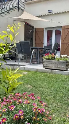 a patio with chairs and a table and flowers at I Tre Taglincchi, U Terzu - Proche mer, Clim, Wifi, Parking gratuit in Taglio-Isolaccio