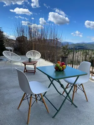 three chairs and a table with a bowl of fruit on it at Très beau studio avec terrasse in Zonza