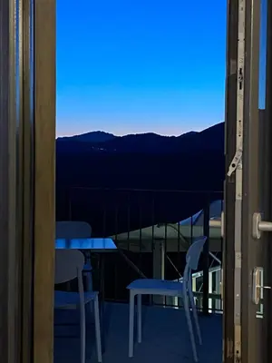 a balcony with a table and chairs and a view of the mountains at Très beau studio avec terrasse in Zonza