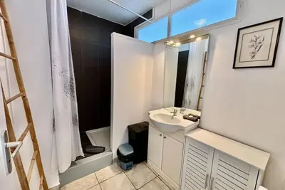 a white bathroom with a sink and a shower at Grand T3 avec vue mer - Proche plage - Parking & AC in Ajaccio