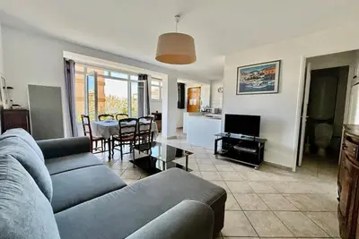 a living room with a couch and a table at Grand T3 avec vue mer - Proche plage - Parking & AC in Ajaccio