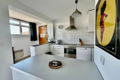 a kitchen with a white counter top in a room at Grand T3 avec vue mer - Proche plage - Parking & AC in Ajaccio