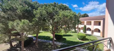 a view of a courtyard with trees and a building at appartement bord de mer en Corse avec 2 piscines 100 metres de la plage in Linguizzetta