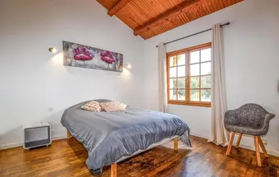 a bedroom with a bed and a window and a chair at Casaperta Aleria in Pancheraccia