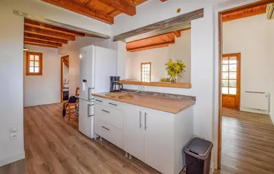 a kitchen with white cabinets and a wooden floor at Casaperta Aleria in Pancheraccia