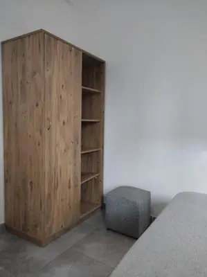 a wooden cabinet in a room next to a bed at T3 Madiana, Climatisé, piscines, resto, 5mn plages in Lecci