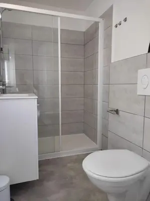 a bathroom with a white toilet and a shower at T3 Madiana, Climatisé, piscines, resto, 5mn plages in Lecci