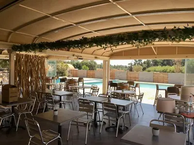 a restaurant with tables and chairs and a pool at T3 Madiana, Climatisé, piscines, resto, 5mn plages in Lecci