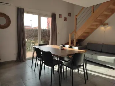 a dining room with a table and chairs and a couch at T3 Madiana, Climatisé, piscines, resto, 5mn plages in Lecci