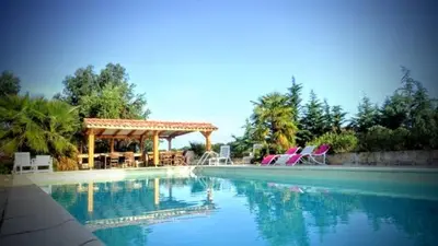 a large swimming pool with chairs and a gazebo at Casalta di san ghjuva in Eccica-Suarella