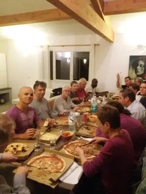 a group of people sitting around a table eating pizza at Casalta di san ghjuva in Eccica-Suarella