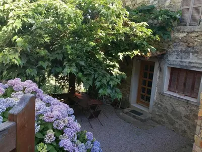 a garden with purple flowers in front of a building at Maison de village calme et agréable in Albitreccia