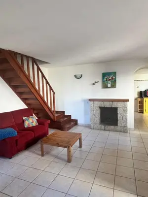 a living room with a red couch and a fireplace at Maison de village calme et agréable in Albitreccia