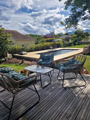 two chairs and a table on a deck next to a pool at casasantellix in Prunelli-di-Fiumorbo