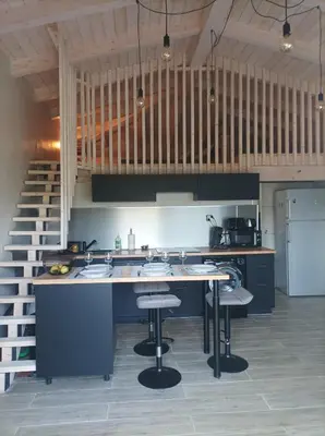 a kitchen with a sink and a counter with stools at casasantellix in Prunelli-di-Fiumorbo