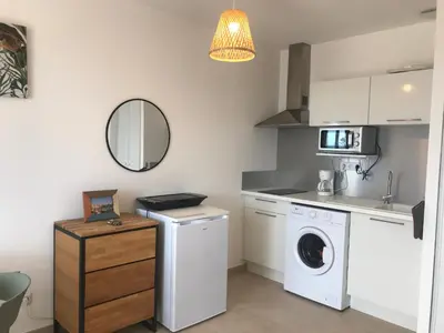 a kitchen with a washer and dryer and a mirror at Studio en bord de mer sur Costa Serena N54 in Linguizzetta