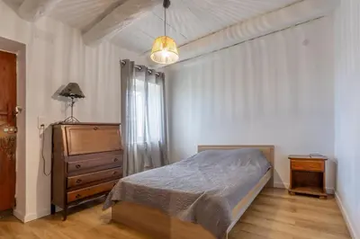 a bedroom with a bed and a dresser and a lamp at Casa Calma - Maison à proximité des plages in Figari