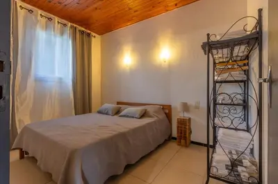 a bedroom with a bed and a iron rack at Casa Calma - Maison à proximité des plages in Figari