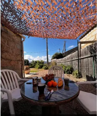 a table with fruit on it on a patio at Casa Calma - Maison à proximité des plages in Figari
