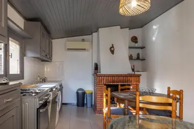 a kitchen with a table and a dining room at Casa Calma - Maison à proximité des plages in Figari
