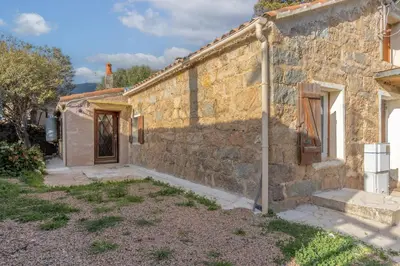 an old stone house with a stone wall at Casa Calma - Maison à proximité des plages in Figari
