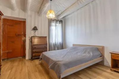 a bedroom with a bed and a dresser and a window at Casa Calma - Maison à proximité des plages in Figari