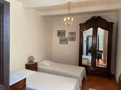 a bedroom with two beds and a large mirror at Appartement familial au cœur du village d’Olmeto in Olmeto