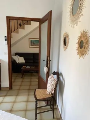 a room with a chair and a living room at Appartement familial au cœur du village d’Olmeto in Olmeto
