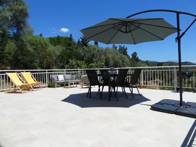 a table and chairs with an umbrella on a patio at Charmant rez de villa, et sa terrasse à Ajaccio in Ajaccio