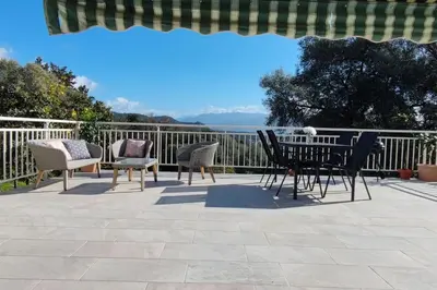 a patio with chairs and a table and a fence at Charmant rez de villa, et sa terrasse à Ajaccio in Ajaccio