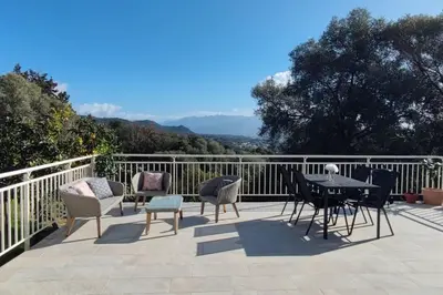 a patio with a table and chairs on a balcony at Charmant rez de villa, et sa terrasse à Ajaccio in Ajaccio