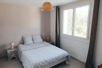 a bedroom with a bed and a window at Charmant rez de villa, et sa terrasse à Ajaccio in Ajaccio