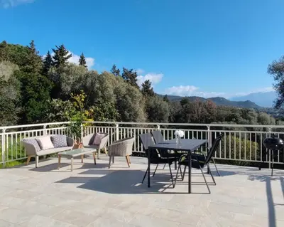 a patio with a table and chairs on a balcony at Charmant rez de villa, et sa terrasse à Ajaccio in Ajaccio
