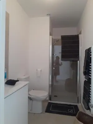 a bathroom with a toilet and a woman standing in a shower at T2 VUE MER MARINA DI BRAVONE N197 in Linguizzetta