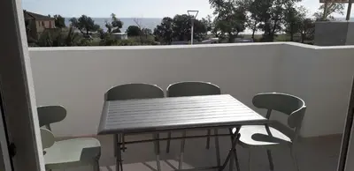 a table and chairs on a balcony with a view of the ocean at T2 VUE MER MARINA DI BRAVONE N197 in Linguizzetta