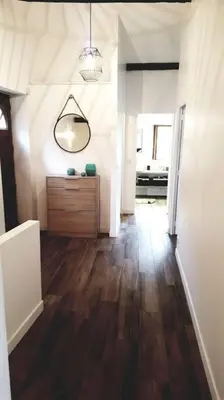 a living room with a wooden floor and a mirror at Magnifique bergerie corse du 17eme Siècle à proximité des plages in Eccica-Suarella