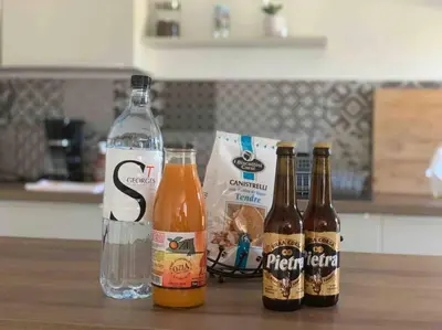 three bottles of beer sitting on a table with a glass at Magnifique bergerie corse du 17eme Siècle à proximité des plages in Eccica-Suarella