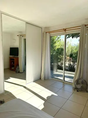 a bedroom with a large mirror and a tv at maison de rêve dans un écrin de verdure au calme in Eccica-Suarella